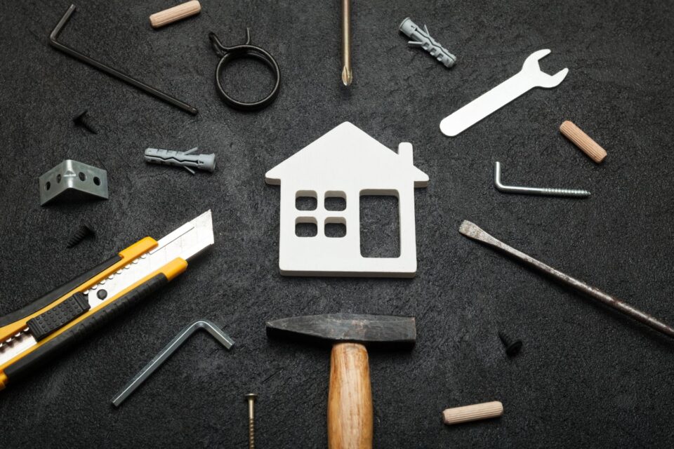 An image of a house surrounded by different tools to repair it