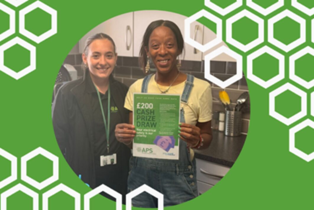 Prize draw winner holding up a poster about the competition and smiling.