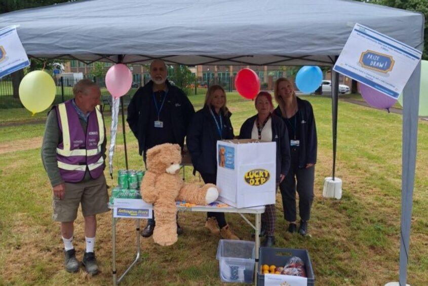 People stood underneath a gazebo in front of a table.