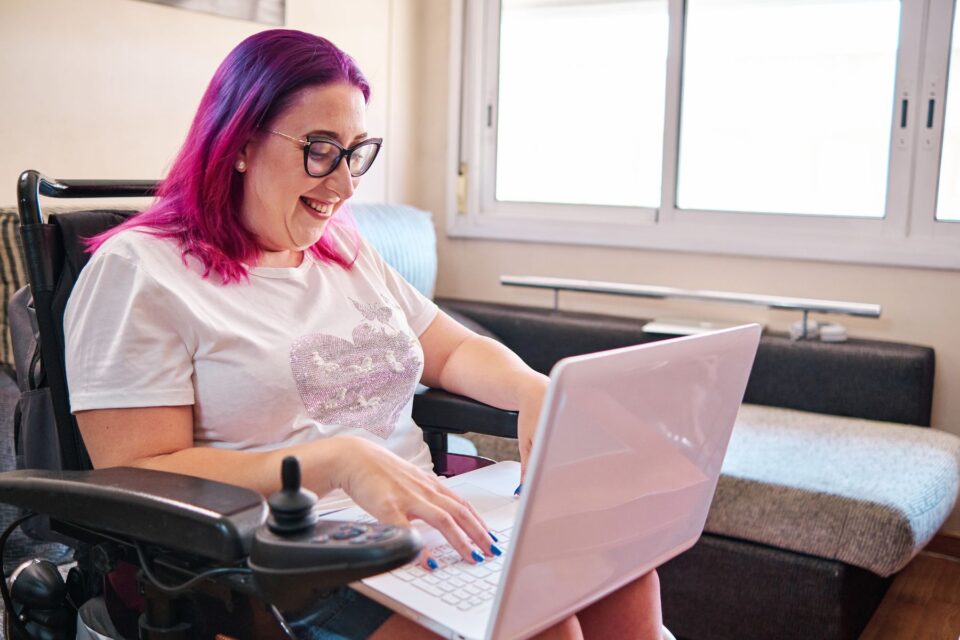 Woman in a wheelchair looking at her laptop