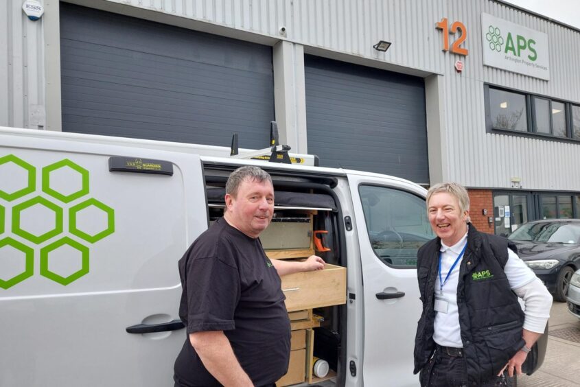 Two members of APS contracting team. They are stood next to a workvan and smiling.
