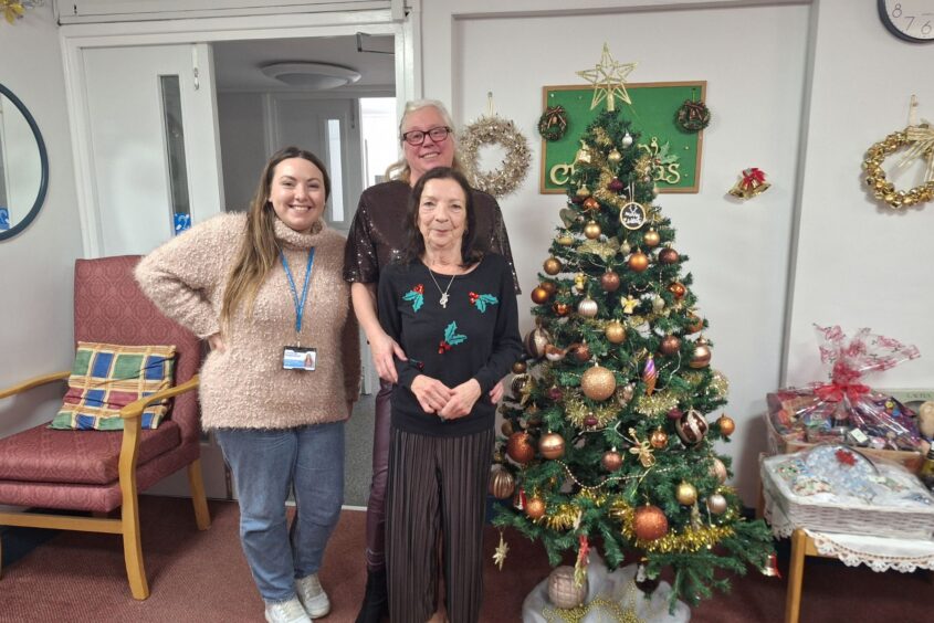 People stood in front of a Christmas tree