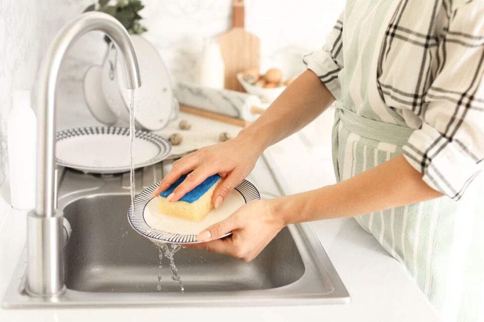 Person washing dishes in a sink