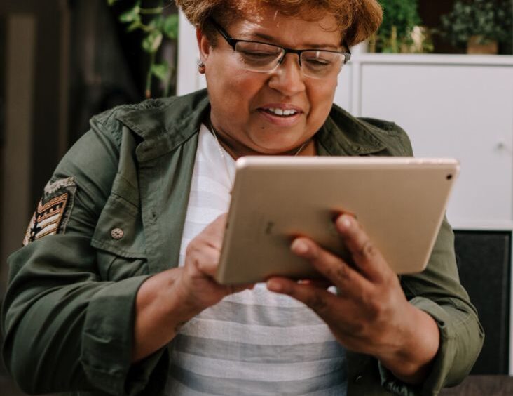 Woman looking at her tablet and smiling