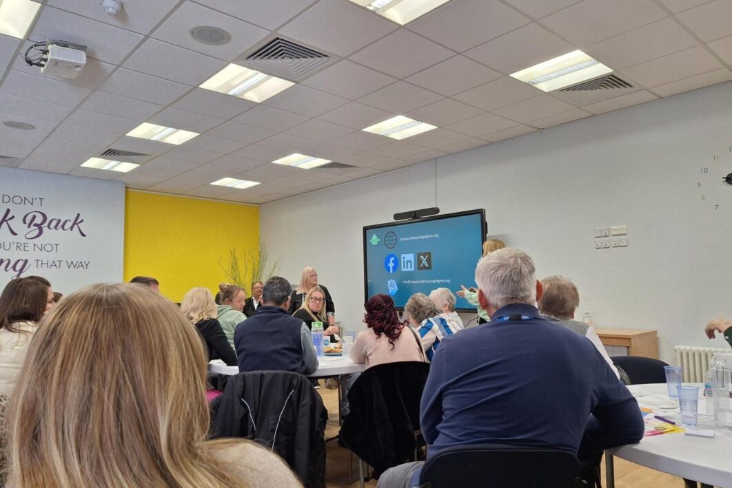 People sitting at people watching a presentation at the front of the room