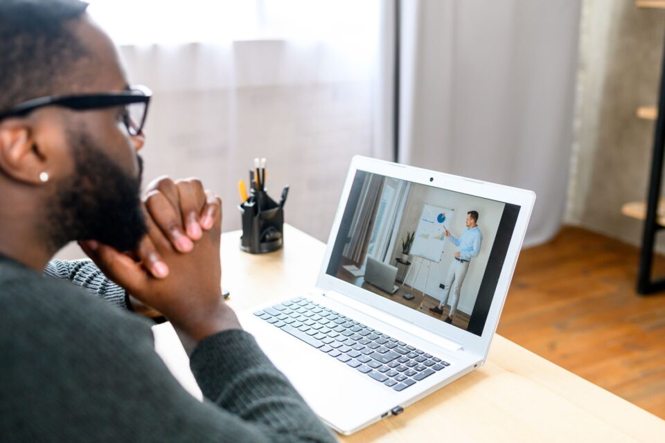Person watching a webinar on their laptop