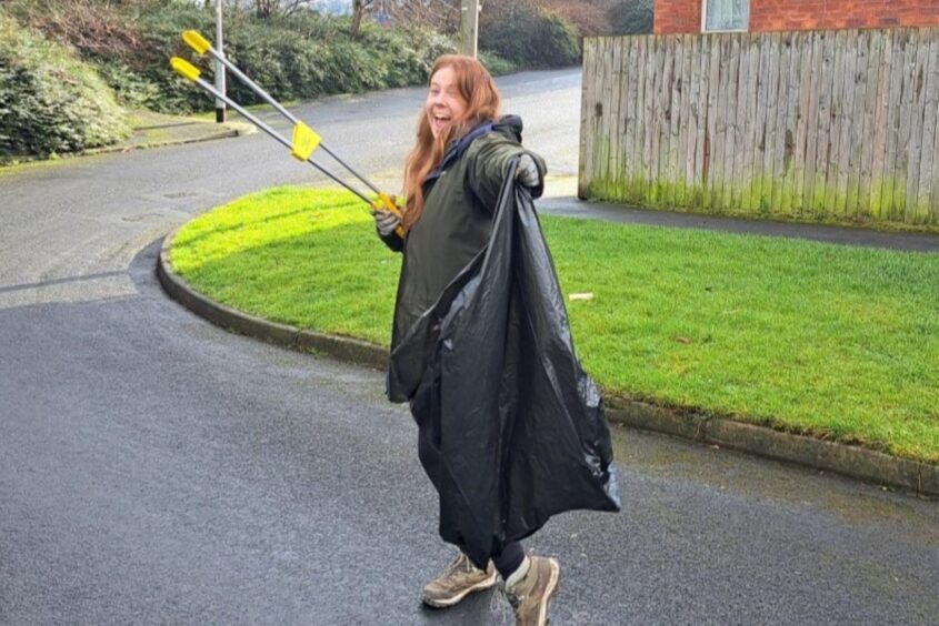 Person holding a bin back litter picking.