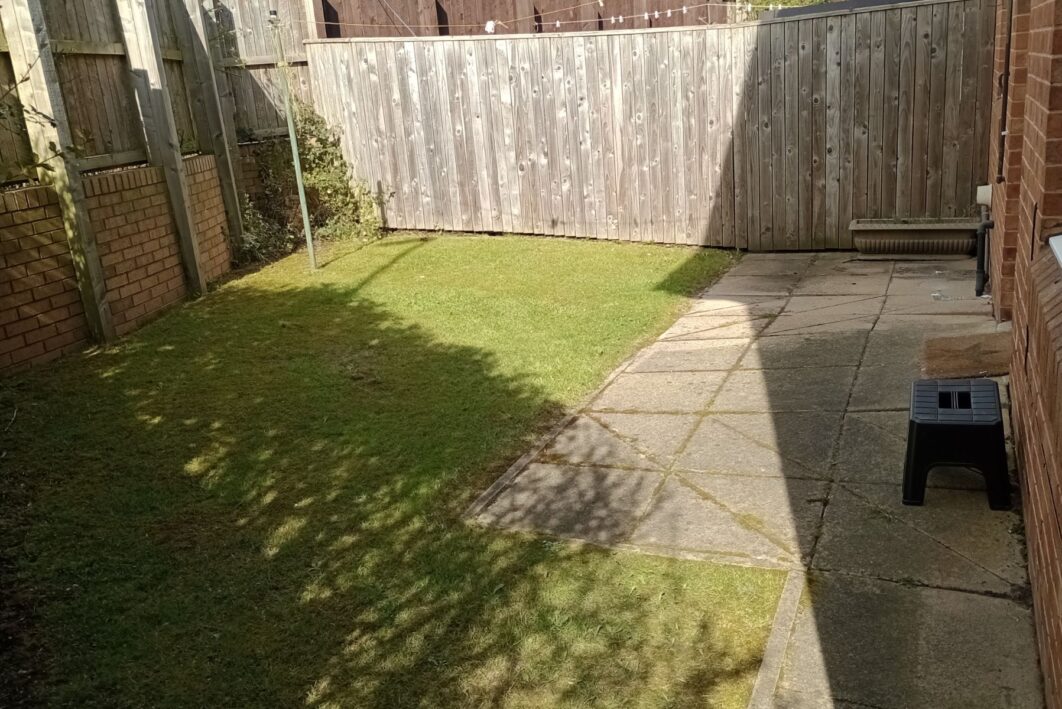 A back garden with a fence
