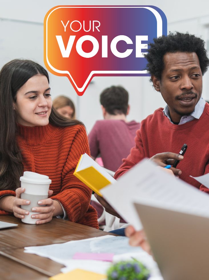 Man and woman chatting with a coffee and notepad. The Your Voice logo is in the background.