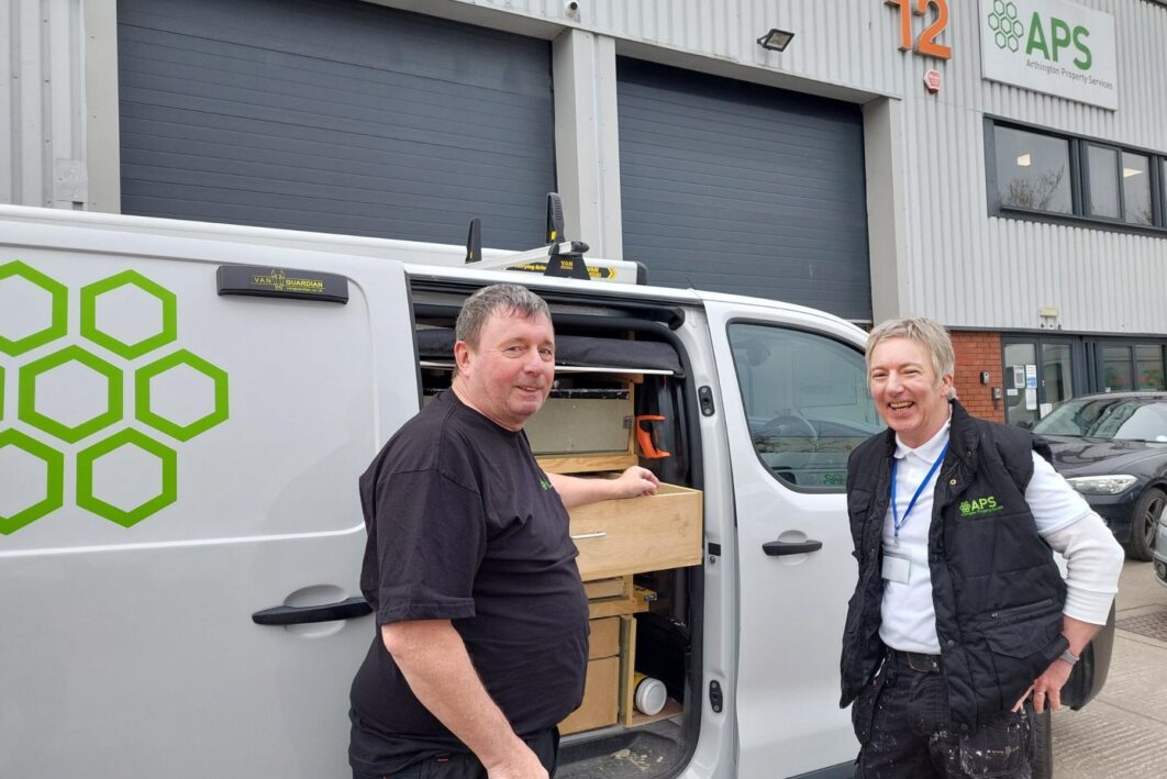 Two men stood in front of a van