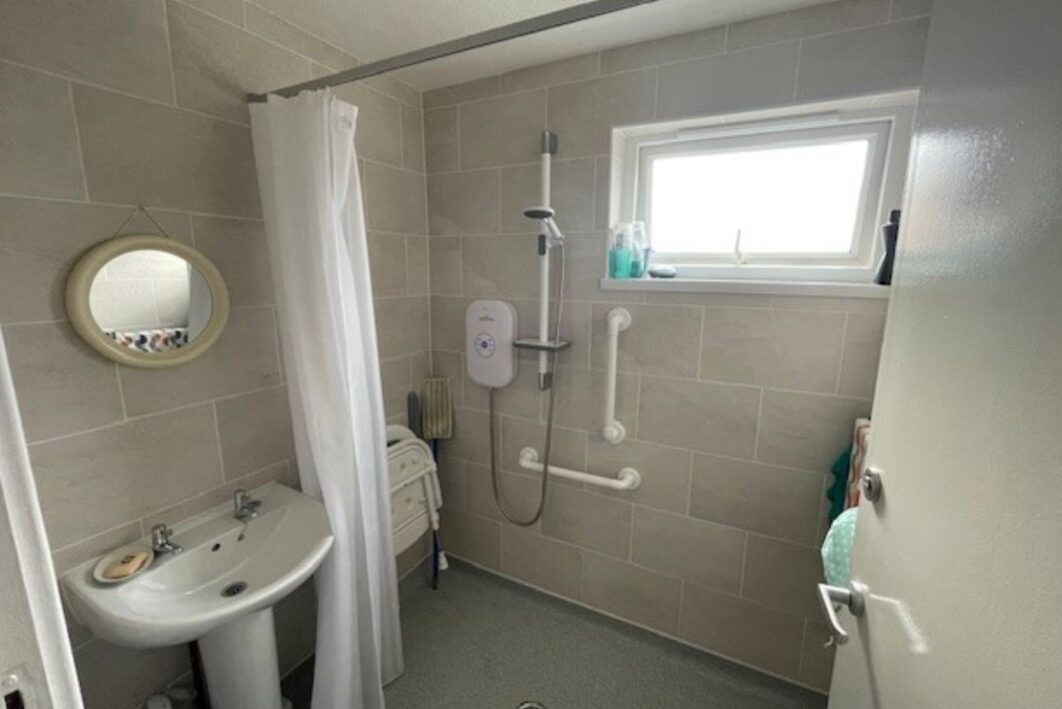 Picture of a wet room that has had an chair fitted next to the shower.