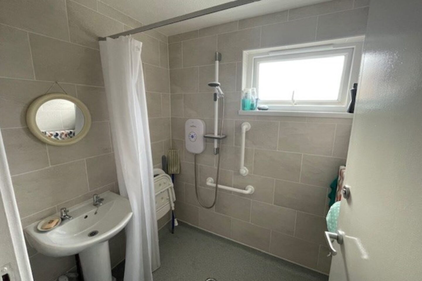 Picture of a wet room that has had an chair fitted next to the shower.