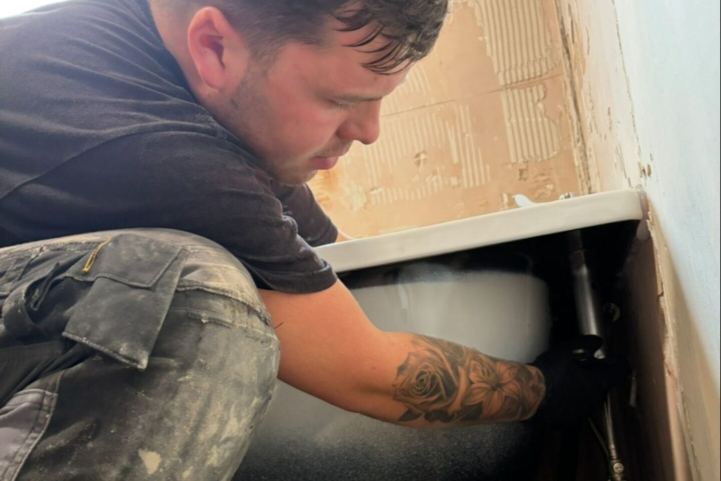 Person fitting a bath into a renovated room