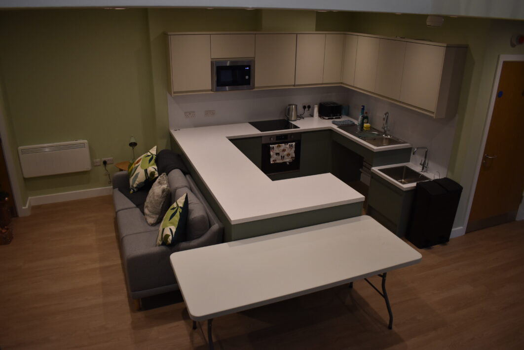 A kitchen with a sofa next to the counter
