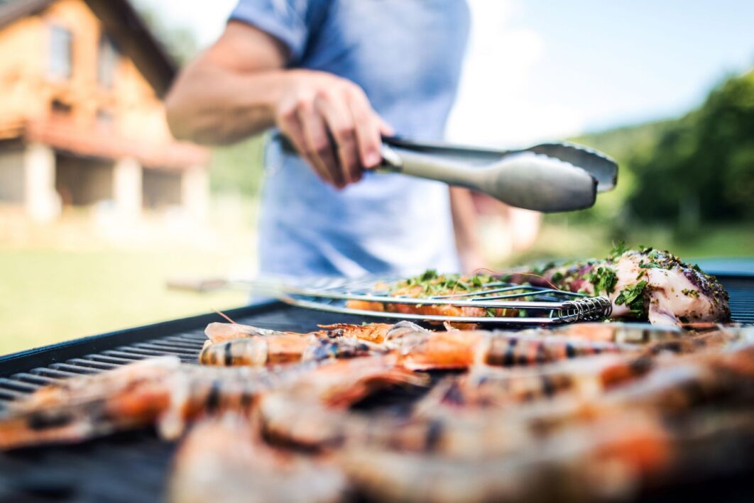 Person grilling meat on bbq
