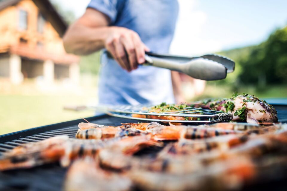Person grilling meat on bbq