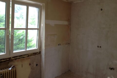 Kitchen with bare plaster walls and units removed