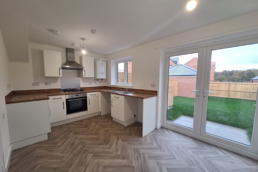 Brand new kitchen with white cupboards and herringbone floor