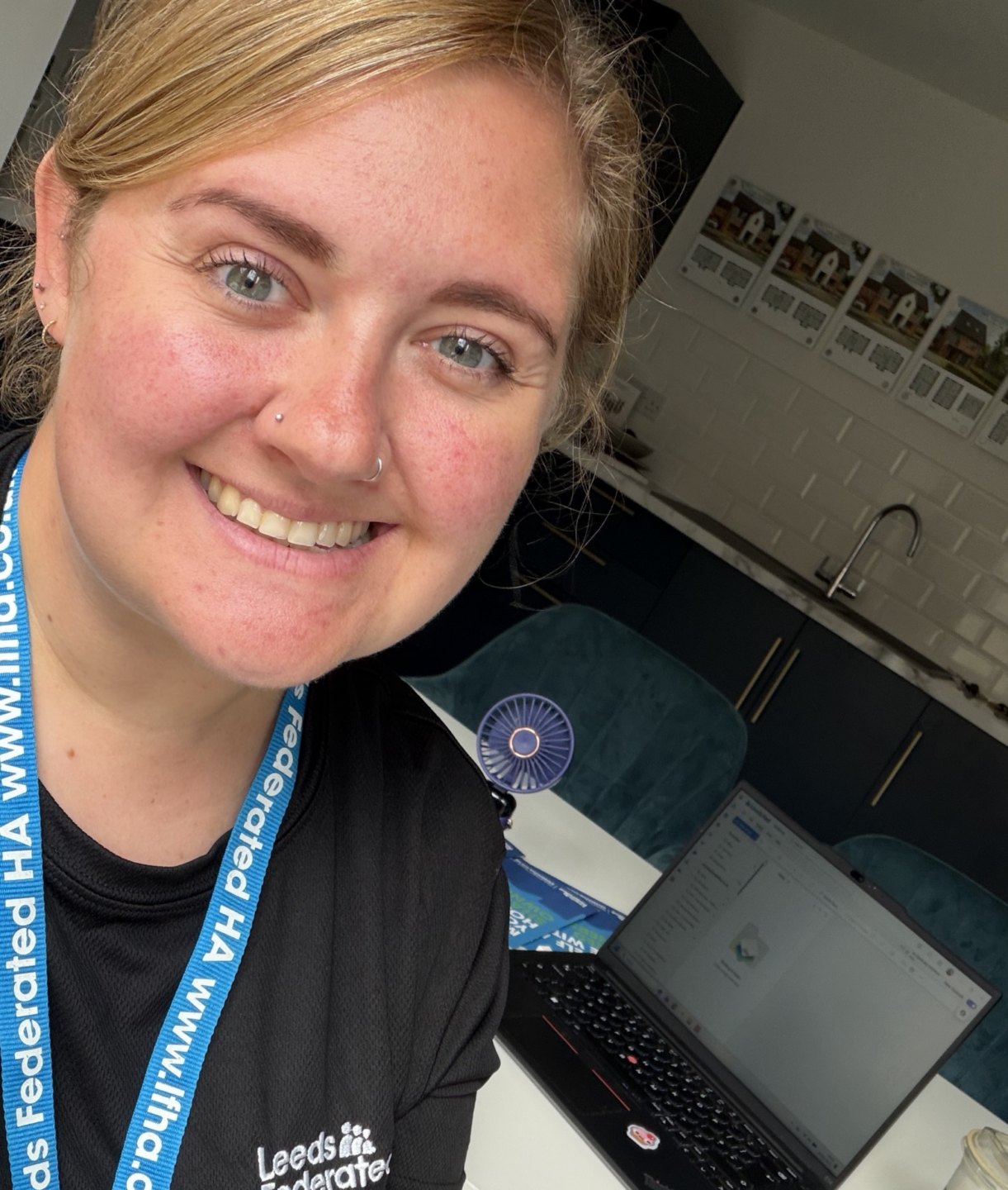 Girl smiling at the camera with laptop behind her and coffee cup