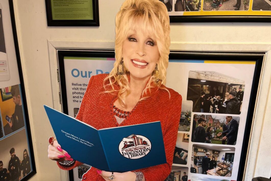 A cardboard cut out of Dolly Parton holding a book that says the Imagination Library