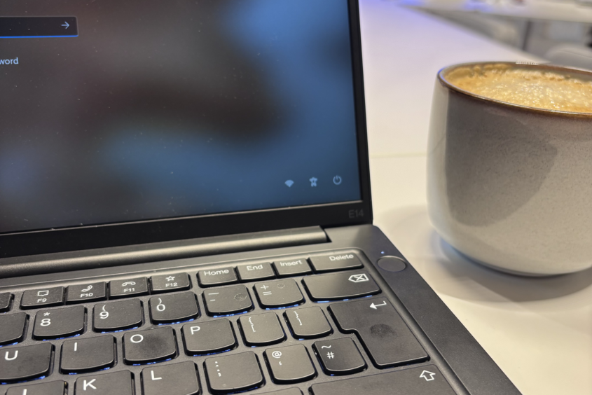 An open aptop with a coffee mug next to it