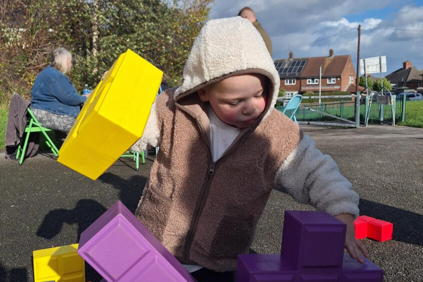 Boy playing with giant tetris block game